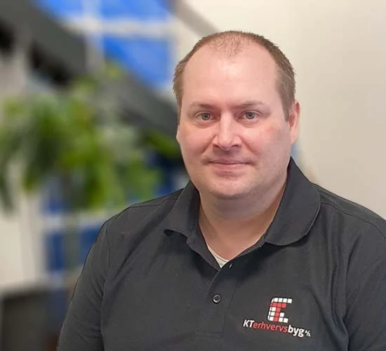 Portræt af en mand i sort poloshirt med logo fra KT Erhvervsbyg A/S