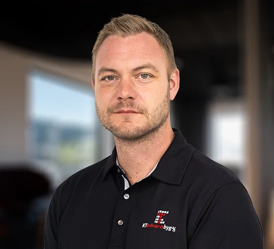 Portræt af en mand i sort poloshirt med logo for KT Erhvervsbyg A/S