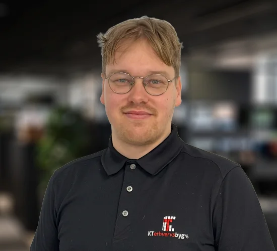 Portræt af en mand med briller og sort poloshirt med KT Erhvervsbyg A/S' logo