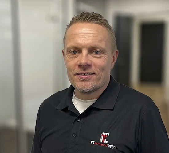 Portræt af en mand i sort poloshirt med logo fra KT Erhvervsbyg A/S