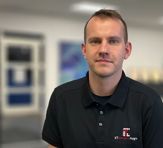 Portræt af en mand i sort poloshirt med logoet for KT Erhvervsbyg A/S