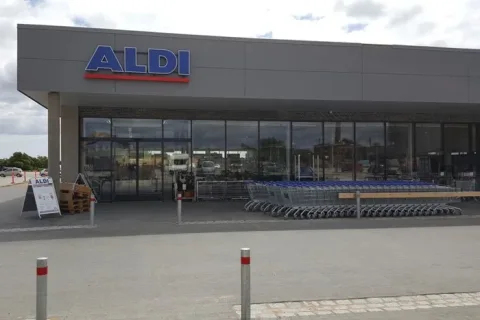 ALDI-butik med glasfacade, indgang og en række indkøbsvogne foran