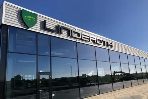 Bilhus med stor glasfacade og Linderoth-skilt over indgangen