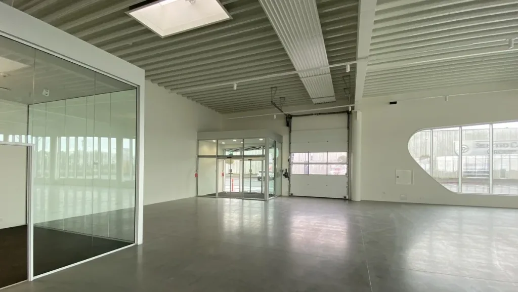 Stort, tomt erhvervslokale med glasvægge, port, højt loft og store vinduer