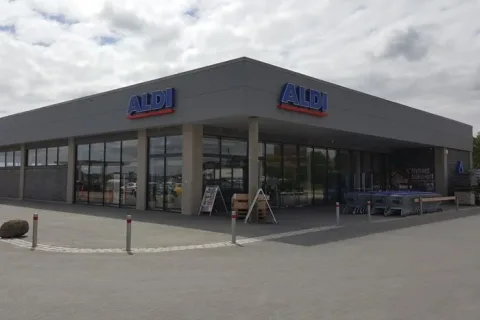 ALDI-butik med grå facade, store glaspartier og indkøbsvogne ved indgangen